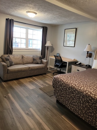 Escritorio, cortinas blackout y tabla de planchar con plancha . Turnpike Motel