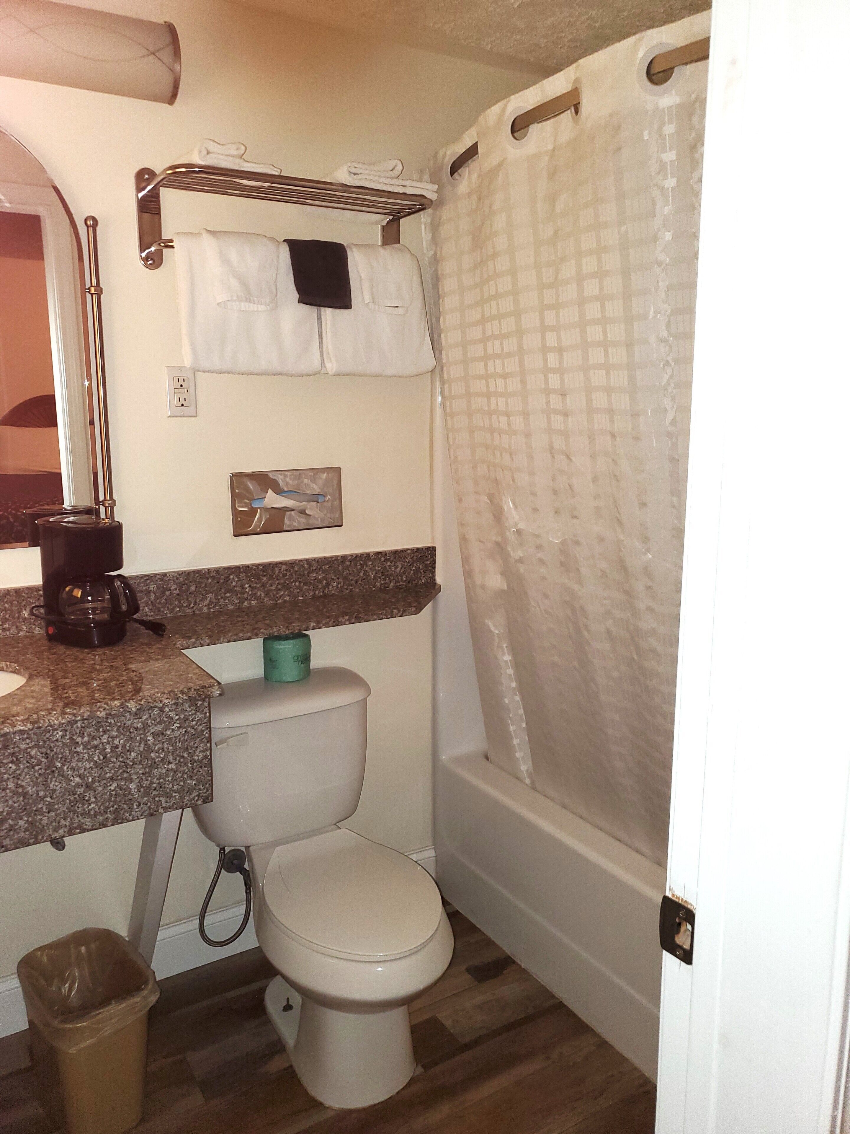 A compact bathroom with a toilet, sink, and shower area.