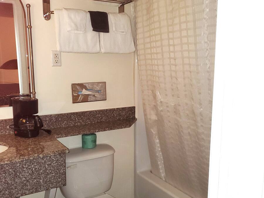A compact bathroom with a toilet, sink, and shower area.