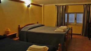 A hotel room with two beds, a nightstand with a lamp, and a window with curtains. - Agriturismo Marco Simone (Rome)