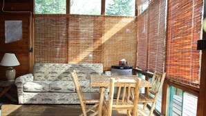 Un interno in legno con divano, tavolo di legno e sedie.