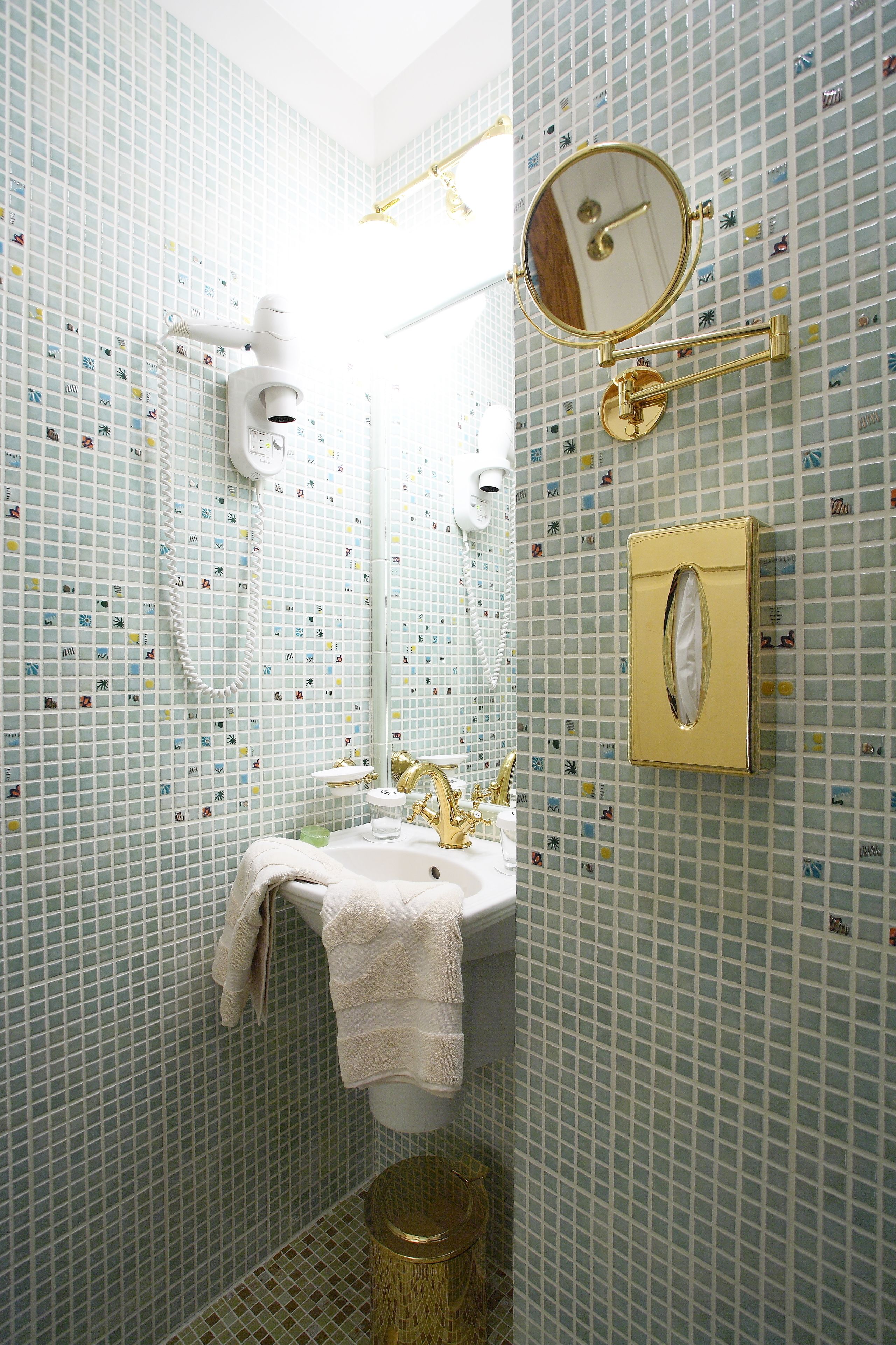 A bathroom with a sink, mirror, and towel rack.