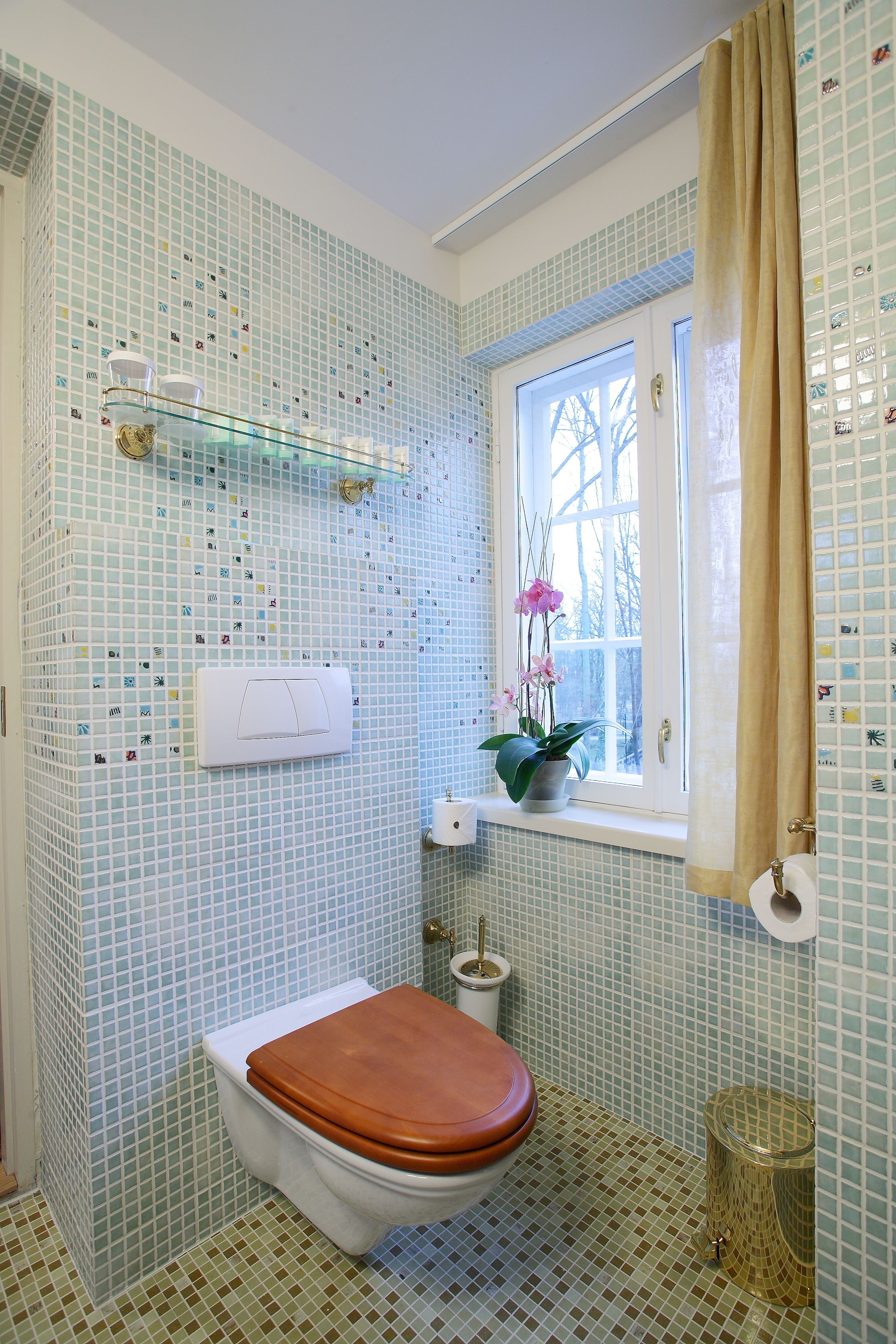 Un baño con inodoro, ventana con vistas, lavabo y espejo.