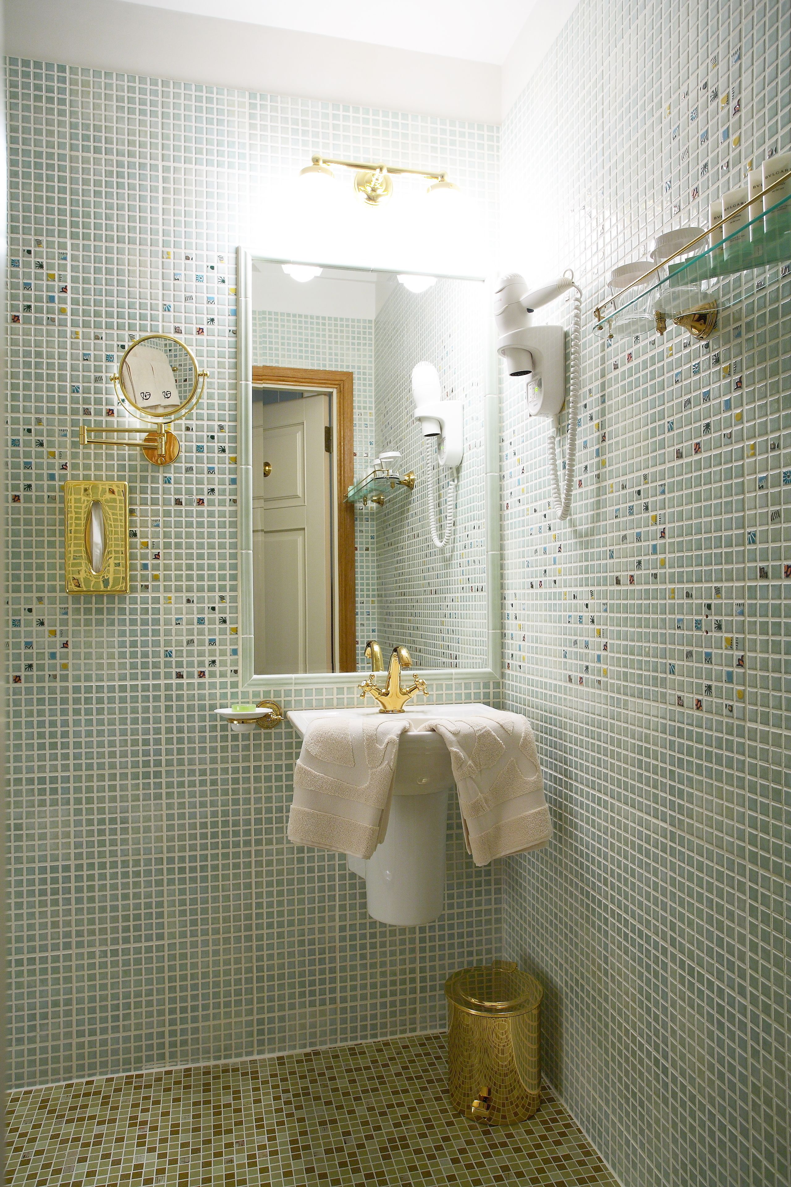 A bathroom with a sink, mirror, and towel rack.
