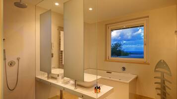 A modern bathroom with a large mirror, a bathtub, and a shower.