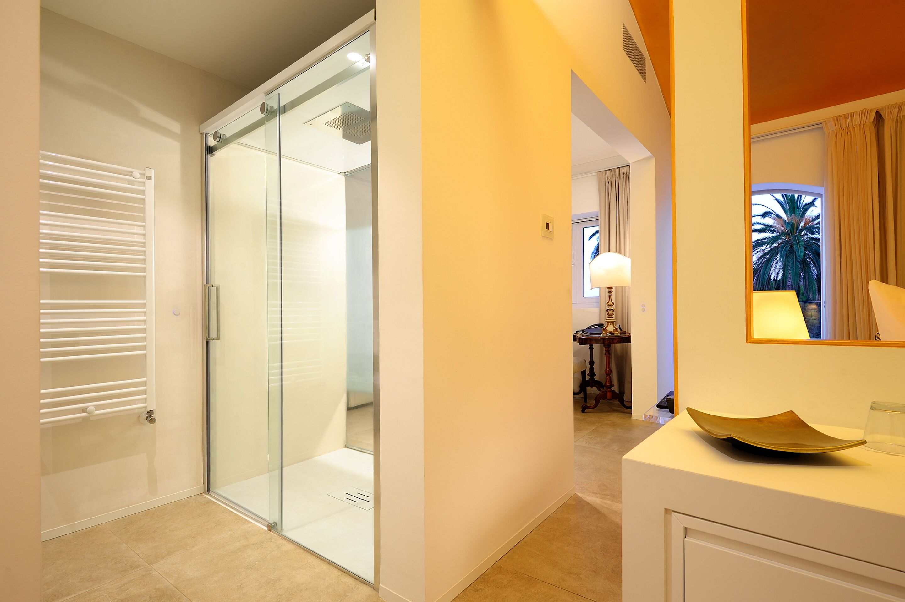 A modern bathroom with a glass shower enclosure, a white vanity with a bowl sink, and a mirror above the sink.