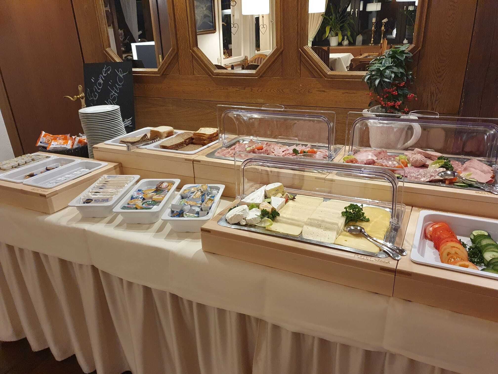 A buffet with various food items including meats, cheeses, and vegetables.