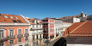 A street view with buildings featuring red-tiled roofs and balconies. - LSA Bairro Alto by Numa (Lisbon)