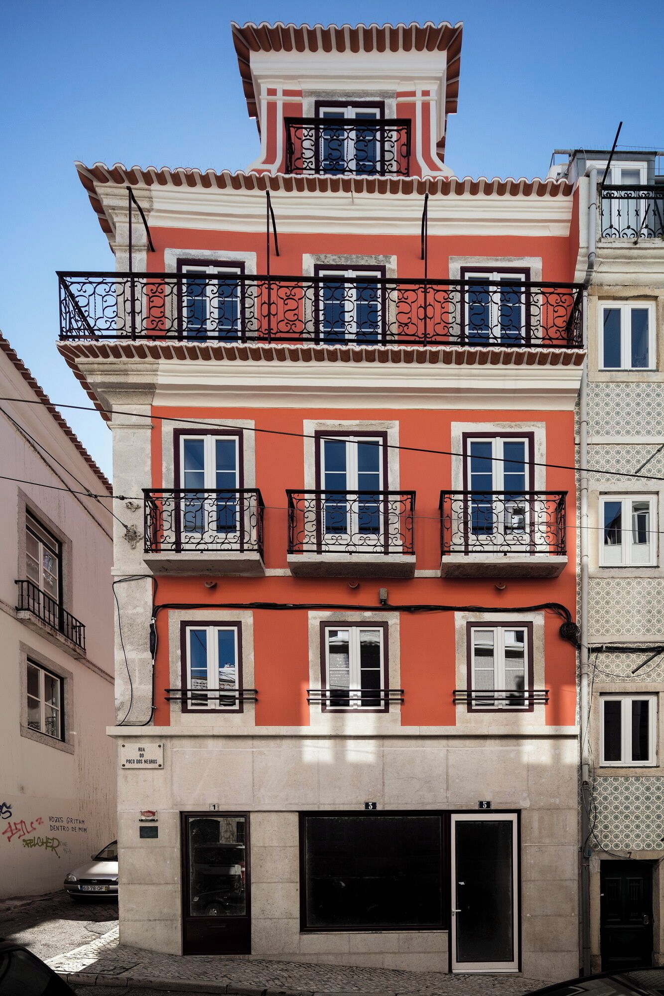 Un edificio de varios pisos con balcones, un garaje y un letrero que indica que es una propiedad residencial.