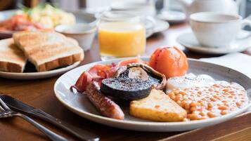 A breakfast plate with toast, beans, eggs, and sausages.