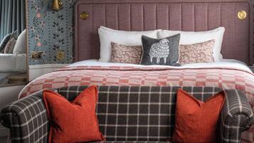 A bedroom with a bed, a sofa, and a coffee table with pastries and cups.