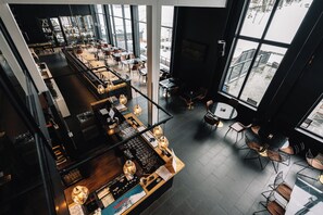 Un interior moderno con zona de bar, asientos y ventanas amplias.