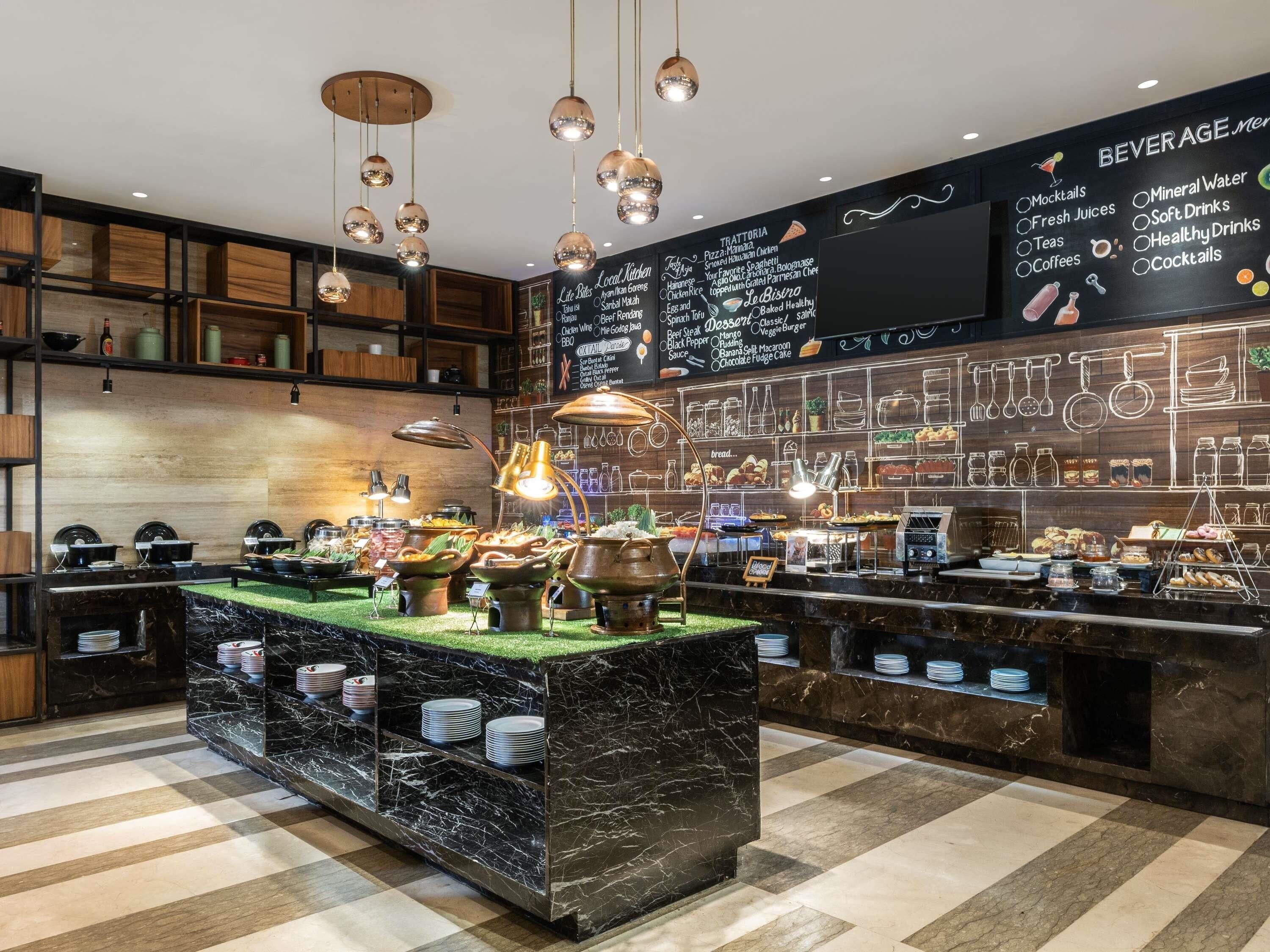 Un restaurant doté d’un comptoir en marbre, de luminaires suspendus et d’un menu écrit à la craie sur un tableau noir.