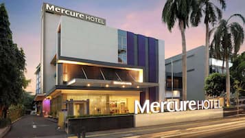 Situated on a street lined with palm trees, the Mercure Hotel boasts a striking architectural design.