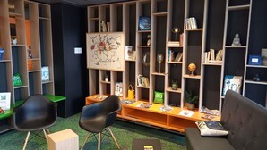 Een bibliotheek met boekenplanken, een bank, stoelen en een kaart aan de muur.