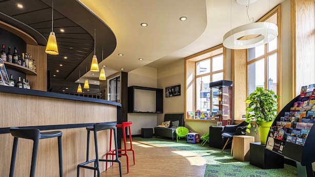 Een bar met krukken, een balie en een groot raam met uitzicht.
