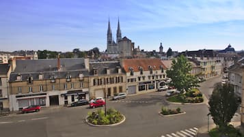 A street view with a prominent church in the background, a roundabout with cars, and buildings with commercial establishments.