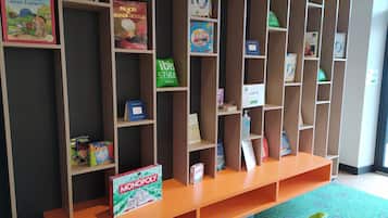 Ein Bücherregal mit verschiedenen Büchern und einem Monopoly-Spiel.