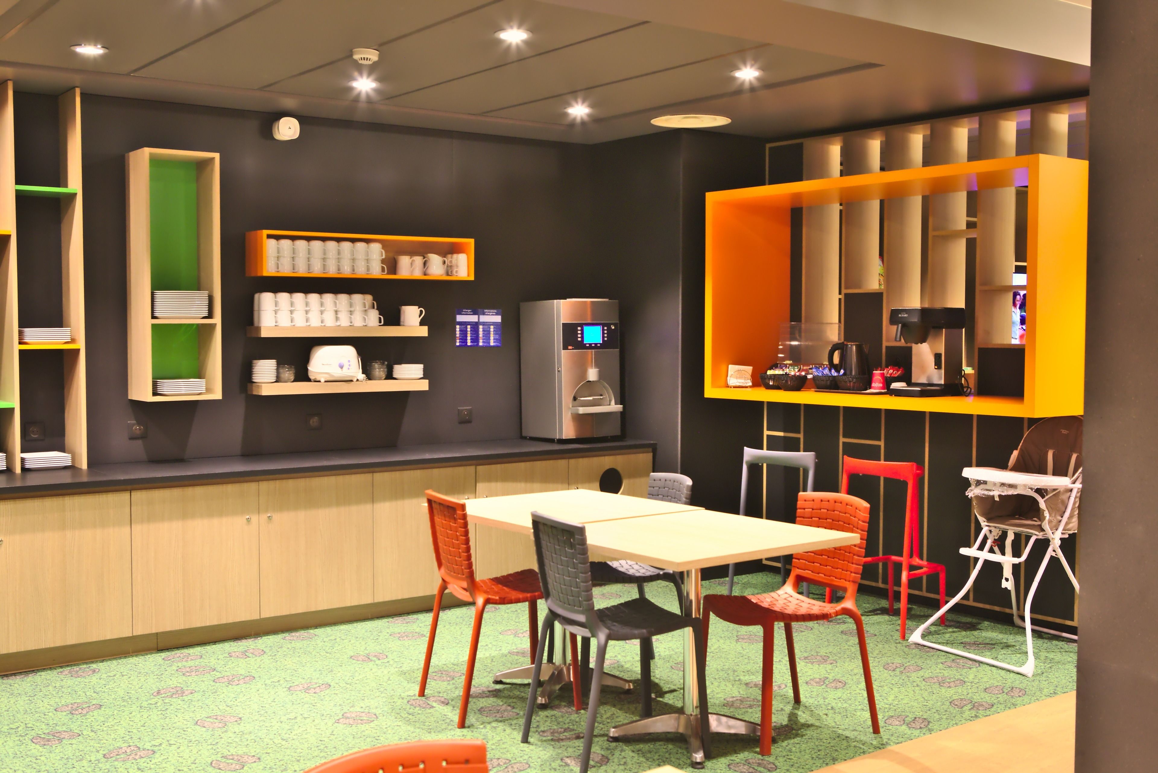 A modern cafe with a wooden counter, shelves with cups and a coffee machine, and a table with chairs.
