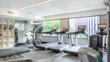 Ein Fitnessstudio mit Laufbändern, Ergometer und einer Gewichtshalterung.