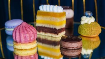 Diversos postres sobre una superficie de vidrio reflectante.