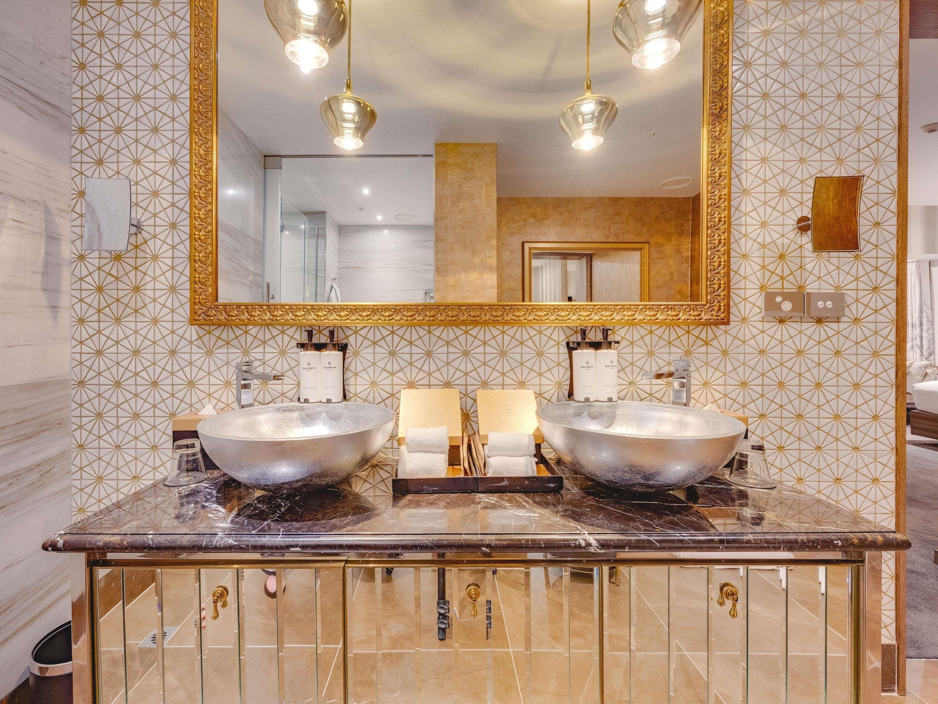 A bathroom with two sinks, a large mirror, and a marble countertop.