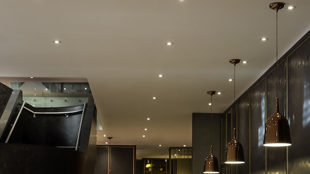 A modern lobby with a central staircase, seating area, and pendant lighting. - Sofitel Wellington (Wellington)