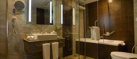 A modern bathroom with a glass-enclosed shower, a sink with a mirror, and a toilet.