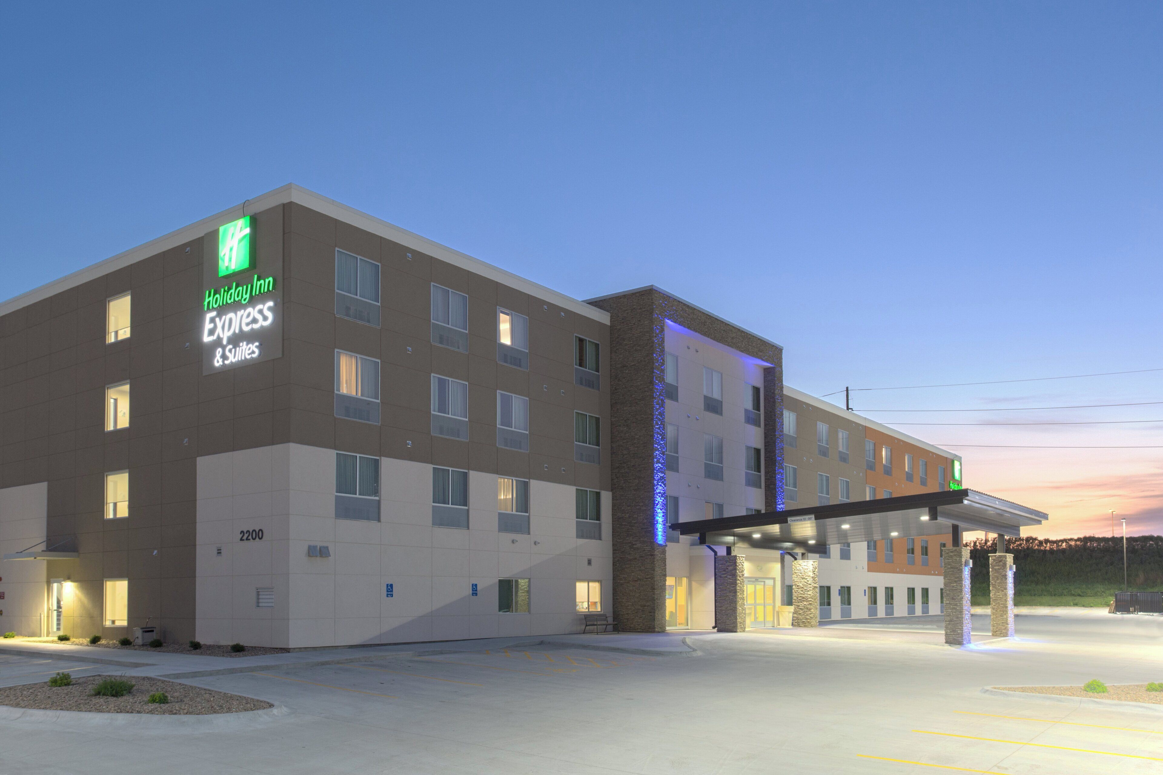 A Holiday Inn Express & Suites hotel with a modern design, multiple floors, and a covered entrance.