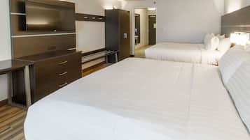 Habitación de hotel con una cama grande, televisión montada en la pared, escritorio y armario.