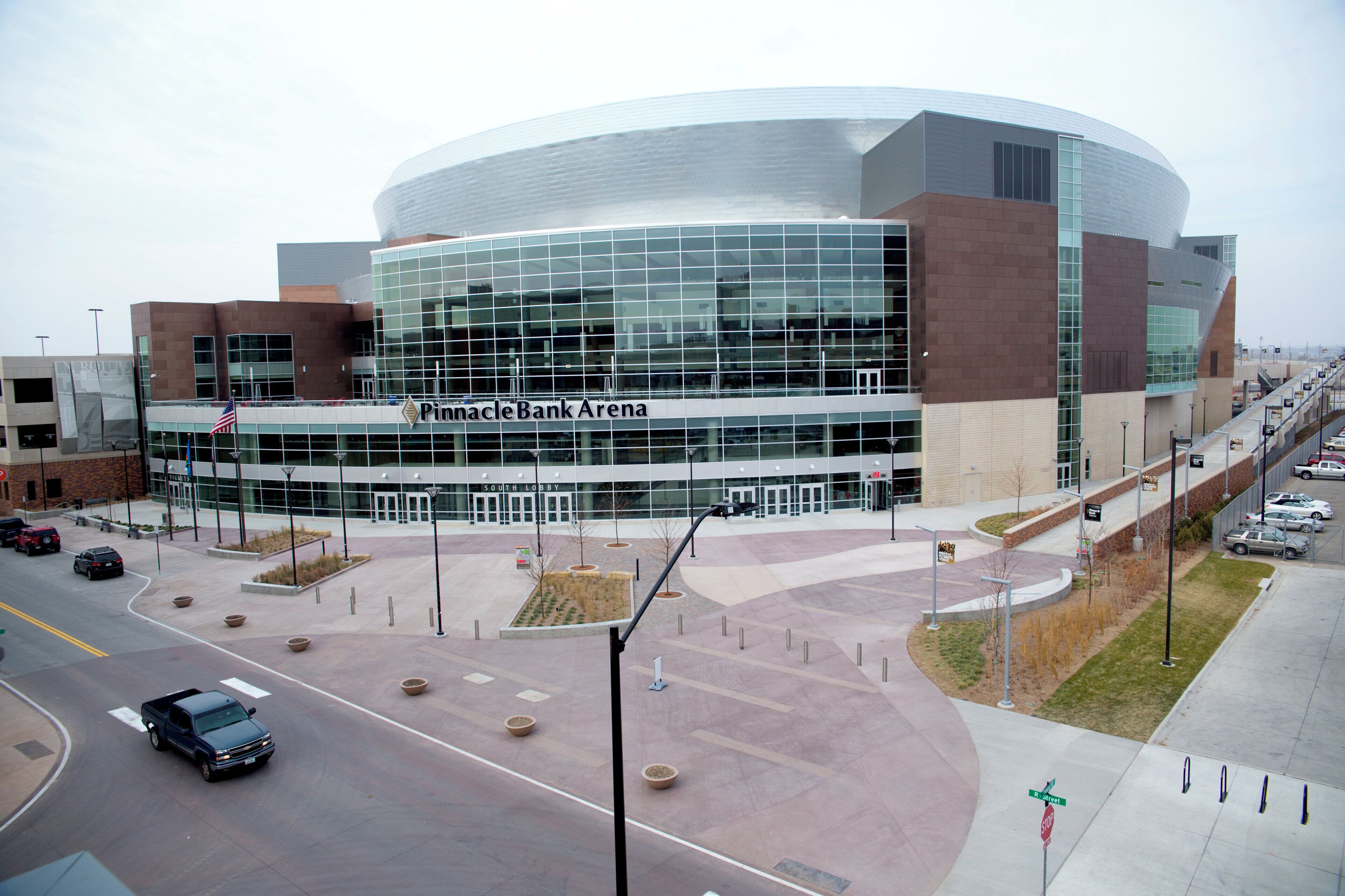 A modern building with a curved glass facade and a sign reading 'Pinnacle Bank Arena'.