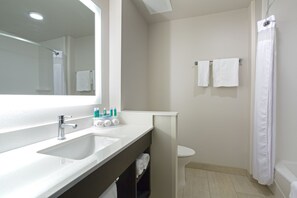 A bathroom with a sink, mirror, and a shower curtain. - Holiday Inn Express and Suites Lincoln I - 80 by IHG (Lincoln)