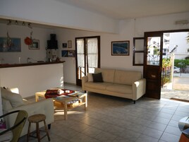 Una sala de estar con un sofá, una mesa de centro y un comedor con mesa y sillas.