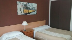 A hotel room with two beds, a nightstand with a lamp, and a painting of a tram on the wall. - Pensión Santa Rita (Santiago de Compostela)