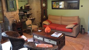 A cozy living room with a sofa, chairs, a coffee table, and a bookshelf.