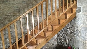 A wooden staircase with a stone wall background.