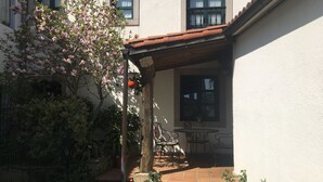 A courtyard with a pergola, outdoor seating, and a blooming tree.