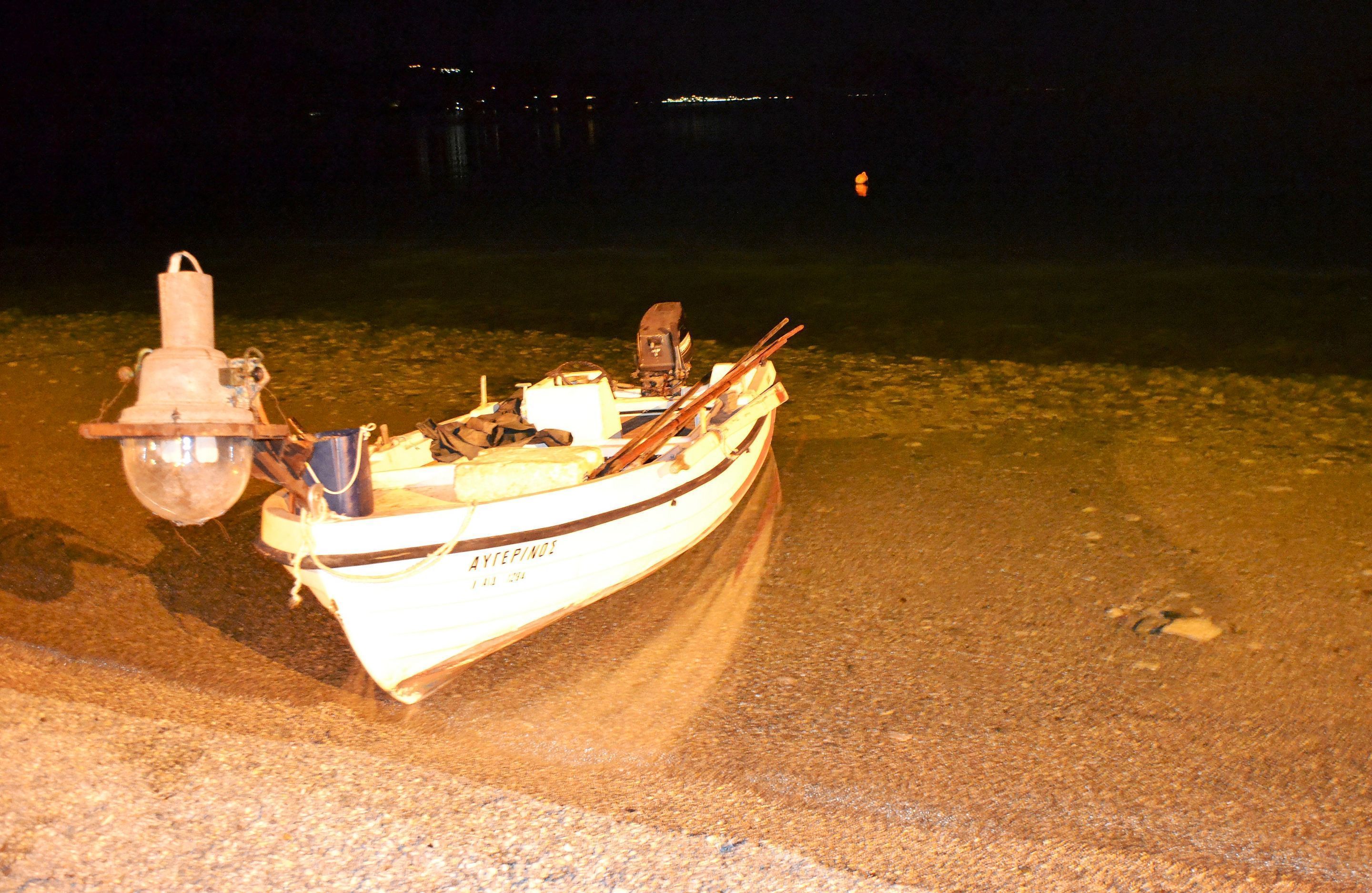 Un pequeño bote con motor y una luz en la orilla de noche.