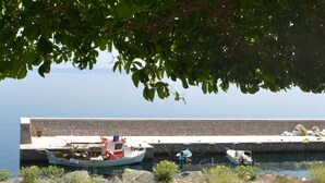 A stone pier with boats docked, surrounded by greenery. - Pharos Rooms (Istiaia-Aidipsos)