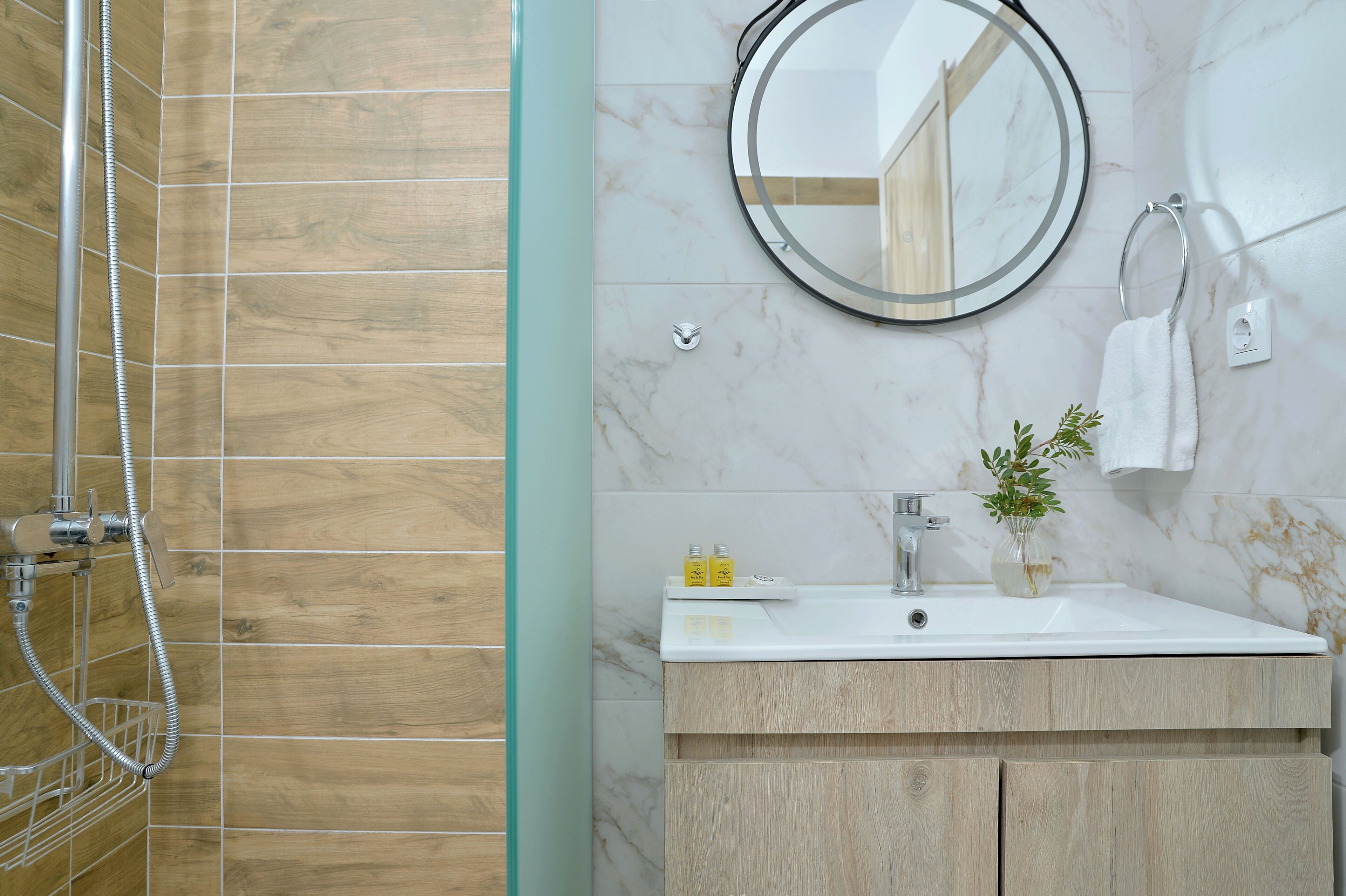 A bathroom with a shower, a sink with a mirror, and a towel rack.