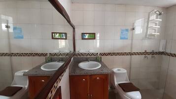 Ein Badezimmer mit zwei Waschbecken, einer Toilette und einer Dusche.