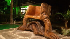 Una escultura de fusta d'un filó damunt una plataforma de pedra.