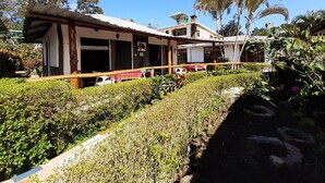 Edifici de dues plantes amb un porxo cobert i una zona de jardí.