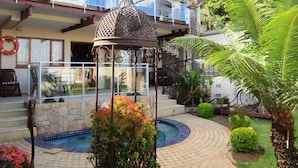 A pool area with a decorative metal gazebo, a small pool, and surrounding greenery. - Kosmos Manor (Hartbeespoort)