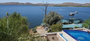 A pool area with a view of a lake and boats. - Kosmos Manor (Hartbeespoort)