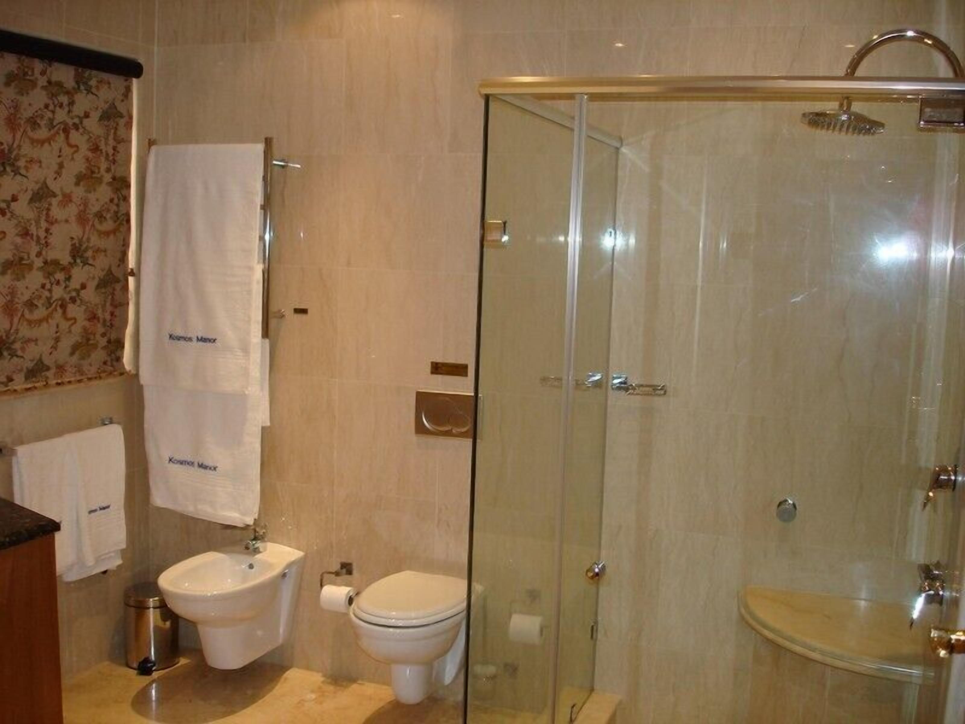 Un baño con ducha de vidrio, inodoro y lavamanos.