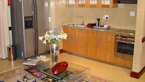A modern kitchen with a stainless steel refrigerator, a built-in oven, and a sink. - Kosmos Manor (Hartbeespoort)