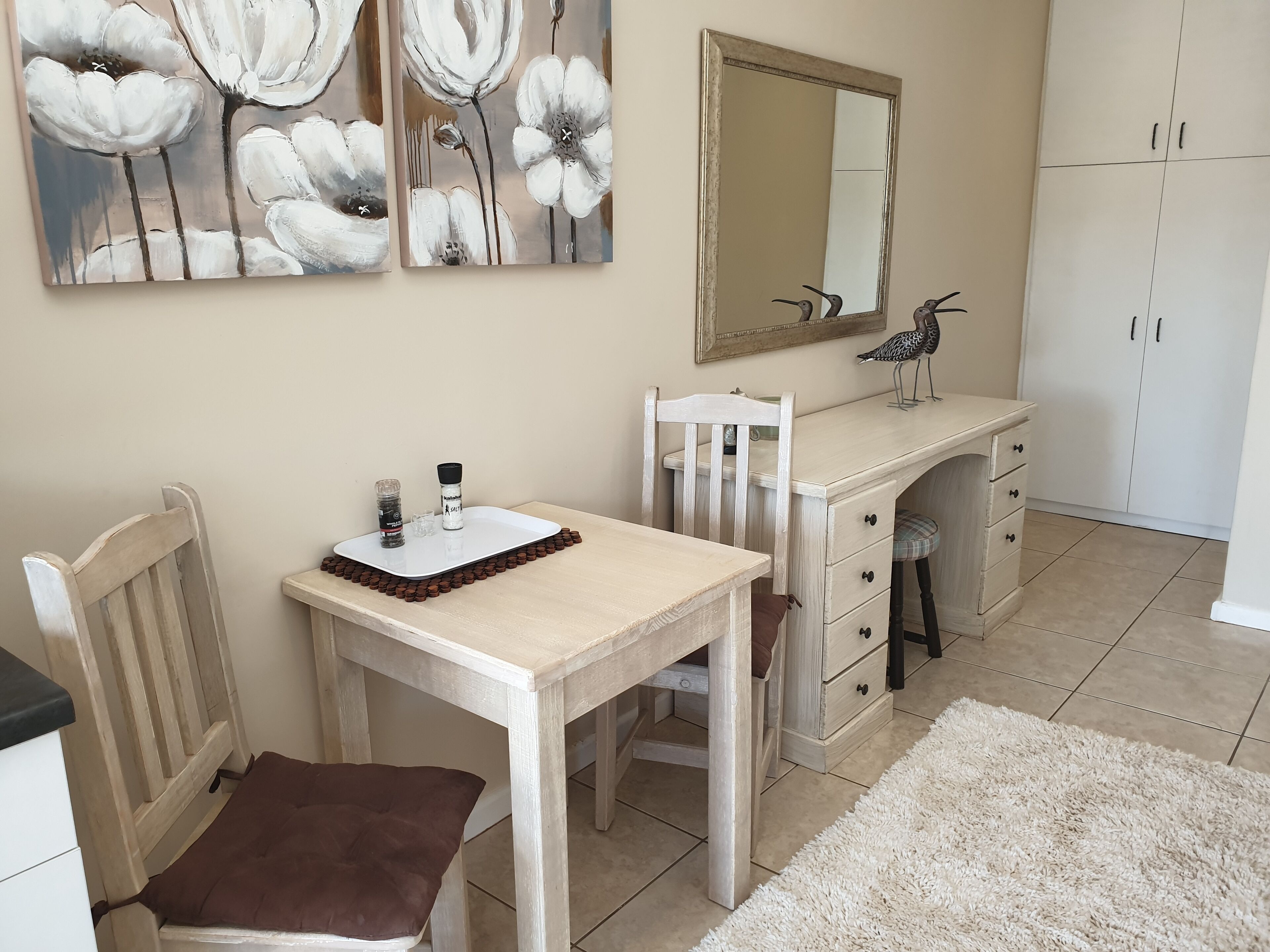 Une chambre à coucher avec un lit en bois, une table de chevet, une chaise, une commode et un miroir.
