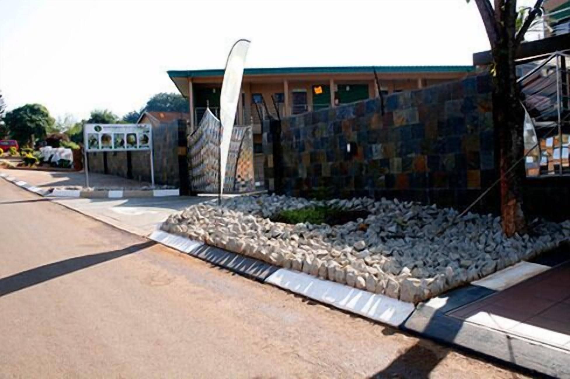 A building with a stone facade and a paved area with a metal fence.