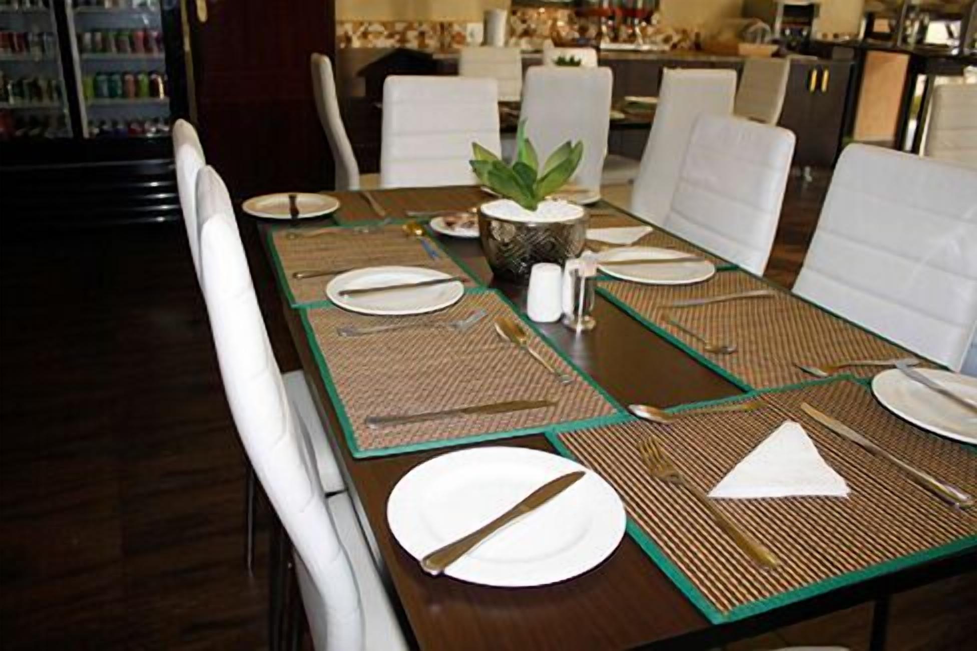 A dining table set with white plates, cutlery, and a decorative centerpiece.